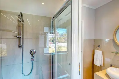 a bathroom with a shower with a glass door at The Links by Top Destinations Rentals in Hermanus