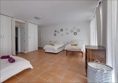 a bedroom with two beds and a tiled floor at Seaclusion in Hermanus