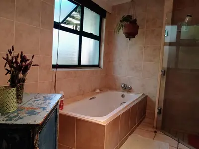 a bath tub in a bathroom with a window at The Farmhouse B&B in Stellenbosch