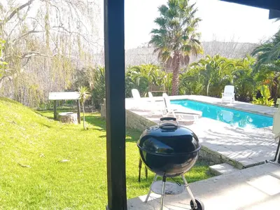 a grill sitting on a table next to a pool at The Farmhouse B&B in Stellenbosch