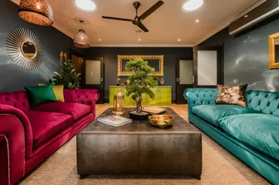 a living room with two couches and a table at SW1 Lodge in Somerset West