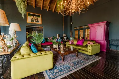a living room with yellow couches and a table at SW1 Lodge in Somerset West