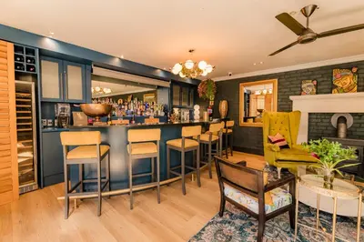 a bar in a room with chairs and a counter at SW1 Lodge in Somerset West