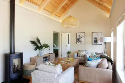 a living room with two chairs and a fireplace at Jardin de la Ferme in Franschhoek