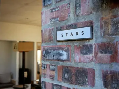a sign on a brick wall with the word stars at Stonehaven Eco Cabins in Hermanus