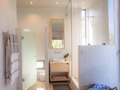 a white bathroom with a sink and a mirror at Stonehaven Eco Cabins in Hermanus