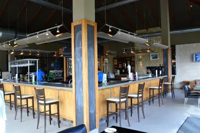 a bar in a restaurant with a bunch of chairs at Pearl Valley-Golf Safari SA in Paarl