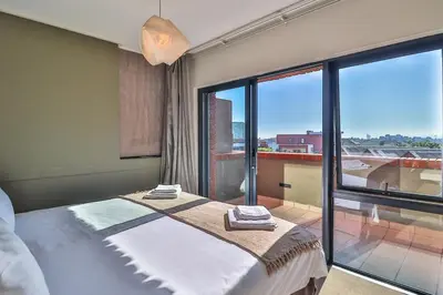 a bedroom with a bed and a large window at Manhattan Towers 506 by CTHA in Cape Town