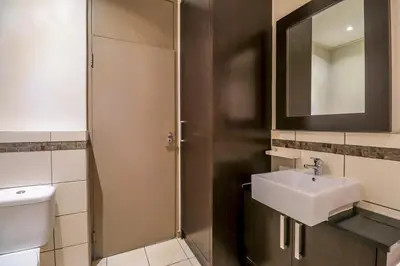a bathroom with a sink and a shower with a mirror at Manhattan Towers 506 by CTHA in Cape Town