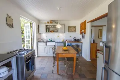 a kitchen with a table and a kitchen with a stove at Porcupine Hills Olive and Guest Farm in Botrivier