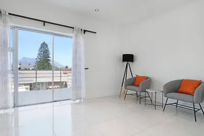 a living room with two chairs and a large window at Prestigious Guest Villa in Cape Town