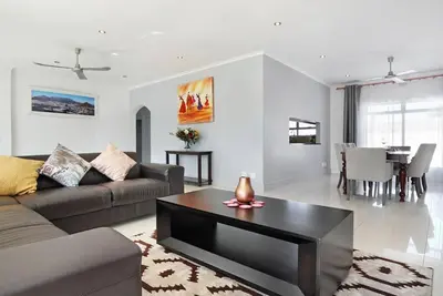 a living room with a couch and a table at Prestigious Guest Villa in Cape Town