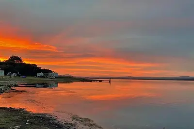 a sunset over a body of water with the sky at Lagoon View in Hermanus in Hermanus