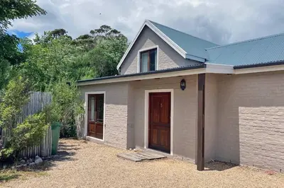 a house with a brown door and a fence at Lagoon View in Hermanus in Hermanus