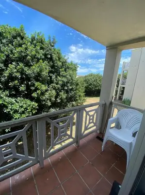 a balcony with a white chair on a porch at Hermanus Beach Club 31 in Hermanus