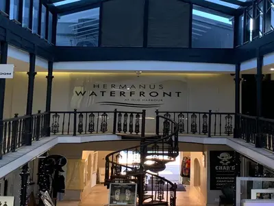 a store with a sign that reads herammums waterfront at Hermanus Waterfront Apartment in Hermanus