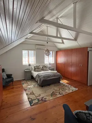 a large bedroom with a bed and a rug at Paradyskloof Suite in Stellenbosch