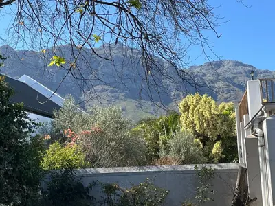 a mountain in the distance with a fence and trees at Paradyskloof Suite in Stellenbosch