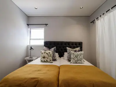 a bedroom with a large bed with two pillows at iMoyo Ocean Villa and Studio, Hermanus in Hermanus