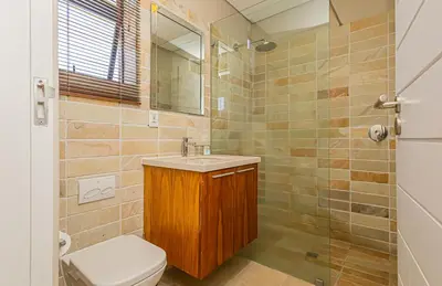 a bathroom with a toilet and a sink and a shower at Ladybird Boutique Hotel at Kanonkop in Stellenbosch