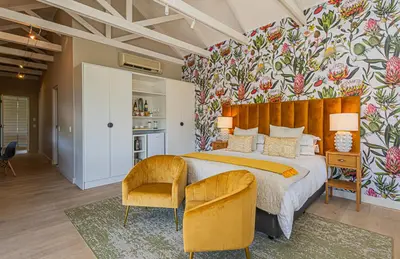 a bedroom with a large bed with a flowery wall at Ladybird Boutique Hotel at Kanonkop in Stellenbosch