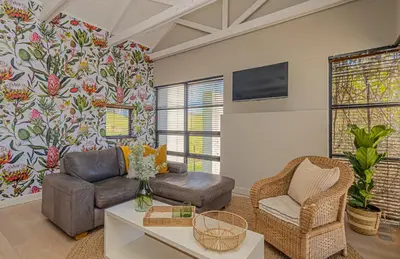 a living room with a couch and a chair at Ladybird Boutique Hotel at Kanonkop in Stellenbosch