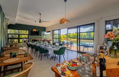 a dining room with a table and chairs and windows at Ladybird Boutique Hotel at Kanonkop in Stellenbosch