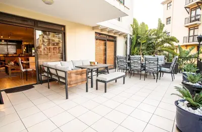 a patio with chairs and a table on a building at Century City Luxury 2 bedroom apartment in Cape Town in Cape Town