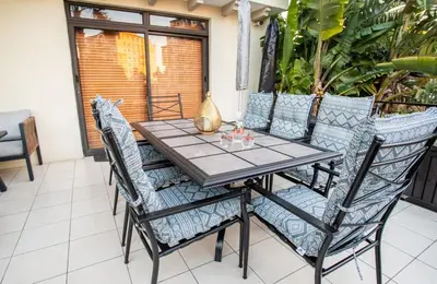 a wooden table and chairs on a patio at Century City Luxury 2 bedroom apartment in Cape Town in Cape Town