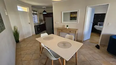 a kitchen and dining room with a table and chairs at La Palmera - Island Club Canal Front in Cape Town