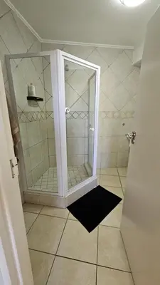a shower with a glass door in a bathroom at La Palmera - Island Club Canal Front in Cape Town