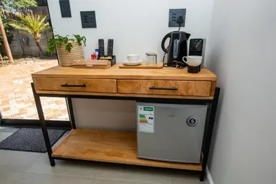 a table with a microwave and a refrigerator under it at Casa iLanga guesthouse in Somerset West