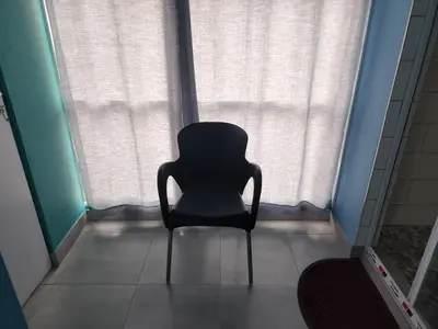 a black chair sitting in front of a window at Hasate Guest House ,4 st james street Oakdale Belliville Cape Town South Africa in Cape Town
