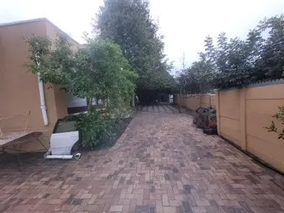 a yard with a fence and a brick driveway at Zenith House Boston Self Catering Accomodation in Cape Town
