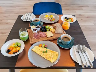 a table with plates of food and cups of coffee at Glow Boutique Suites & Guesthouse in Hermanus