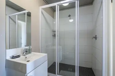 a bathroom with a sink and a shower at 2 Bedroom Secure Pool Strong WiFi in Cape Town