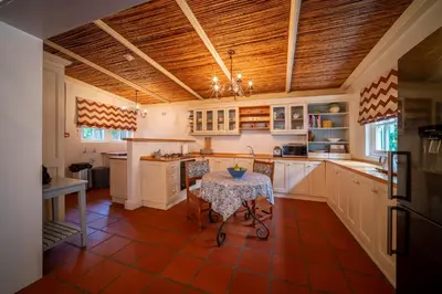a kitchen with a table in the middle of it at Wild Olive House at Bartholomeus Klip in Hermon