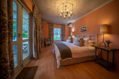 a bedroom with a bed and a large window at Wild Olive House at Bartholomeus Klip in Hermon