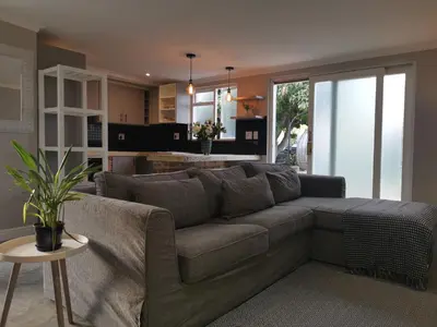 a living room with a couch and a kitchen at Gray Cottage in Strand