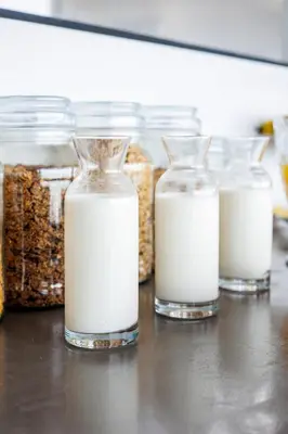 a group of glass jars of milk on a table at OnTheRocksBB Solar Powered Guesthouse and Ocean Lodge in Bettyʼs Bay