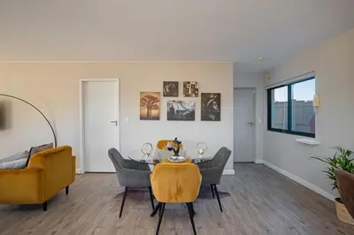 a living room with a table and chairs at Knightsbridge Terrace in Cape Town
