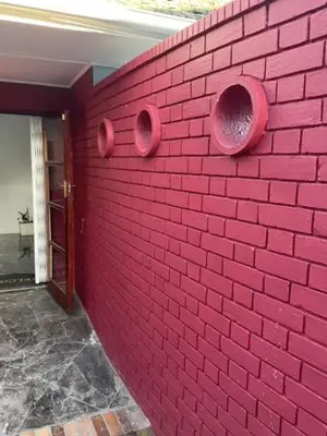 a pink brick wall with two holes in it at Cub's Home in Cape Town