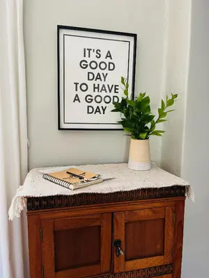 a picture on a wall with a plant on a cabinet at THE CORNER COTTAGE in Somerset West