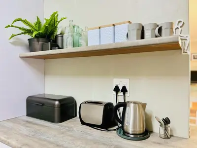a kitchen shelf with a toaster and a coffee maker at THE CORNER COTTAGE in Somerset West