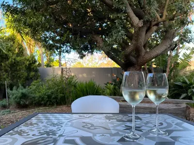 two glasses of white wine sitting on a table at THE CORNER COTTAGE in Somerset West