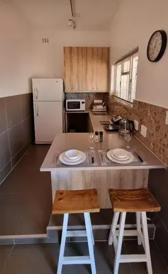 a kitchen with a island with two chairs and a counter top at The Ridge in Cape Town