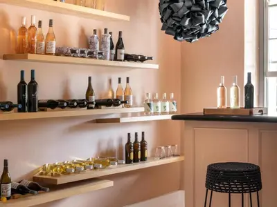 a wine tasting room with bottles and glasses on shelves at Greyton Lodge in Greyton