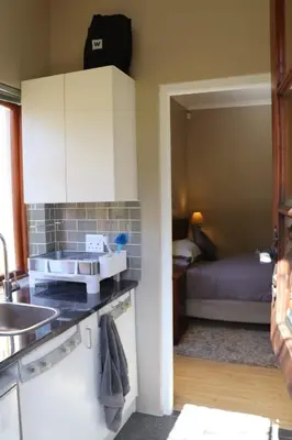 a kitchen with a sink and a bed in a room at Tranquility Studio in Somerset West