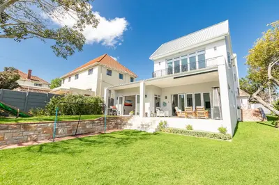 a white house with a yard at Spacious Guest Apartment in Rondebosch in Cape Town