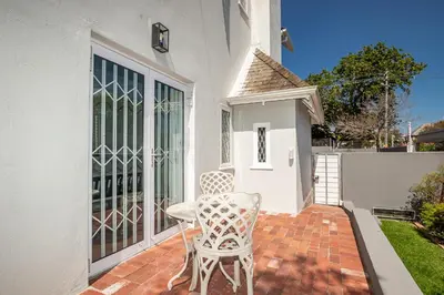 a white chair sitting on a brick patio at Spacious Guest Apartment in Rondebosch in Cape Town